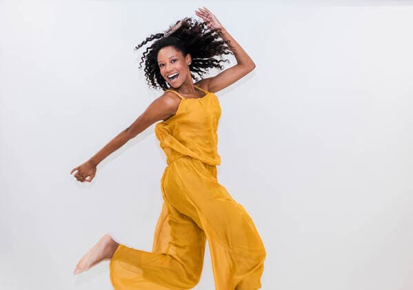 Creative Highlights Symbolbilder Carefree woman dancing while jumping on white background model released Symbolfoto JRVF01341