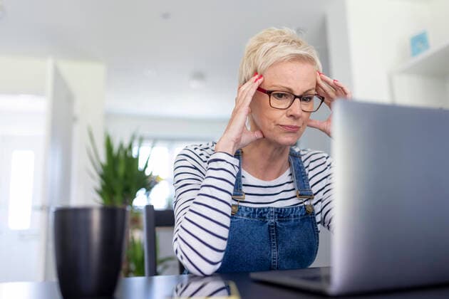 IMAGO Creative: Internationaler Frauenmonat, Gesundheit, Frauen in der Menopause Frustrated female professional looking at laptop in home office model released Symbolfoto property released WPEF05126