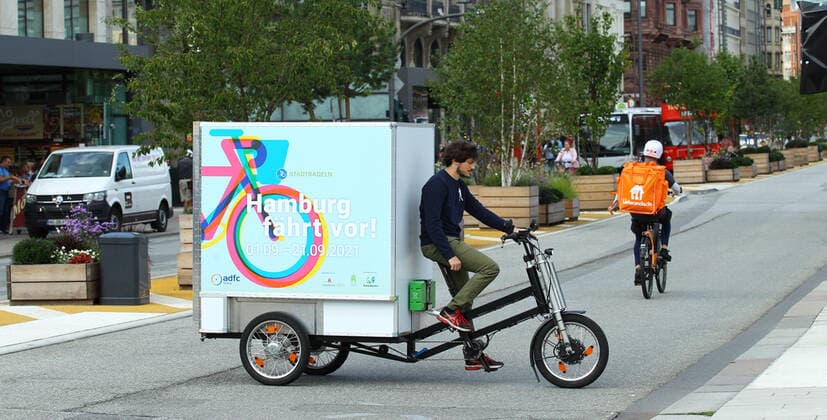 Fototermin PR-Termin für das diesjährige Stadtradeln in Hamburg. Die bundesweite Kampagne des Netzwerks Klima-Bündnis findet in diesem Jahr zum 14. Mal statt. Startschuss für die Aktion in Hamburg ist am 1. September. Ein Mann fährt auf einem Lastendreirad den Jungfernstieg entlang. Altstadt Hamburg