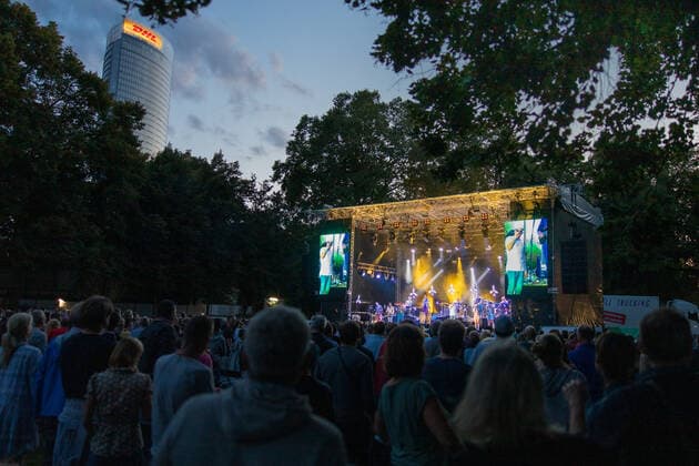 Das Konzertgeländer des Kunst!Rasen in Bonn - Der Hip Hop Funk und Soul Musiker Jan Delay (Jan Philipp Eißfeldt) und die Band Disko No. 1 beim Live Auftritt auf dem Kunst!Rasen Bonn Gronau. Veranstalter ELHartz Promotion GmbH Bonn Gronau NRW Deutschland