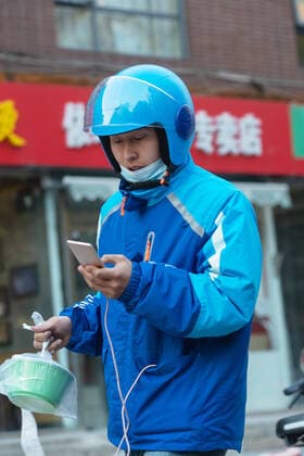 Apply to eat takeout China, 10 11 2020, model released, Copyright: xViewxStockx, Ref:cpmh-217549f07w.jpg, Takeaway clerk,Service industry occupation,Delivery Person,Asia,Asian and Indian Ethnicities,East Asia,Oriental Ethnicity,china,Chinese Ethnicity,Adult,Young Adult,Men,Only Men,One Person,People,Outdoors,Walking,Holding,Take Out Food,Looking,Mobile Phone,Communication,Taxiing,Efficiency,Convenience,Beat The Clock,Struggle,Overalls,Hardhat,Professional Occupation,Occupation,City Life,Fast Food,Service,Expressing Positivity,Effort,Well-dressed,Well Being,Mask,prevent epidemics,Looking Away,Vertical,Waist Up,Photography,Color Image,Selective Focus,25-29 Years Copyright: xViewxStockx