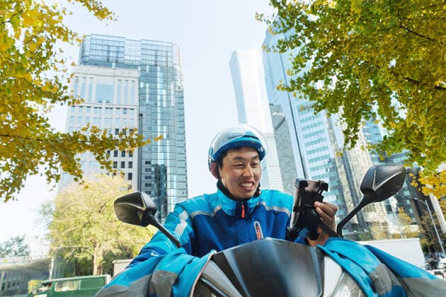 Check the take-away member of the mobile phone China, 10 11 2020, model released, Copyright: xViewxStockx, Ref:cpmh-217709f07w.jpg, Takeaway clerk,Service industry occupation,Delivery Person,Asia,Asian and Indian Ethnicities,East Asia,Oriental Ethnicity,china,Chinese Ethnicity,Adult,Young Adult,Men,Only Men,One Person,People,Outdoors,Riding,Motorbike,Smiling,Toothy Smile,Looking,Mobile Phone,Communication,Efficiency,Convenience,Struggle,Effort,Overalls,Hardhat,Professional Occupation,Occupation,City Life,Service,Take Out Food,Expressing Positivity,Well-dressed,Cheerful,Fun,Confidence,Responsibility,Well Being,Day,Looking Away,Horizontal,Waist Up,Photography,Color Image,Focus On Foreground,Low Angle View,Front View,25-29 Years Copyright: xViewxStockx