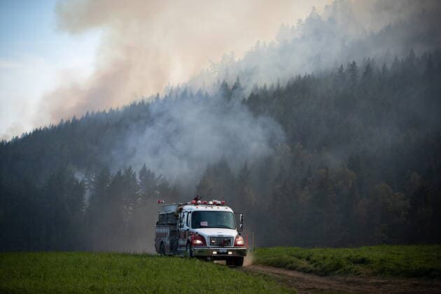 August 25, 2021, VERNON, BC, Canada: Firefighters drive across a farm while monitoring a controlled burn the B.C. Wildfire Service conducted to help contain the White Rock Lake wildfire on Okanagan Indian Band land, northwest of Vernon, B.C., on Wednesday, August 25, 2021. VERNON Canada  - ZUMAc35_ 20210825_zaf_c35_059 Copyright: xDarrylxDyckx