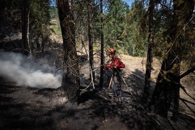 August 25, 2021, VERNON, BC, Canada: Wildland firefighter Katie Devaney sprays water on hot spots remaining from a controlled burn the B.C. Wildfire Service conducted to help contain the White Rock Lake wildfire on Okanagan Indian Band land, northwest of Vernon, B.C., on Wednesday, August 25, 2021. VERNON Canada  - ZUMAc35_ 20210825_zaf_c35_066 Copyright: xDarrylxDyckx