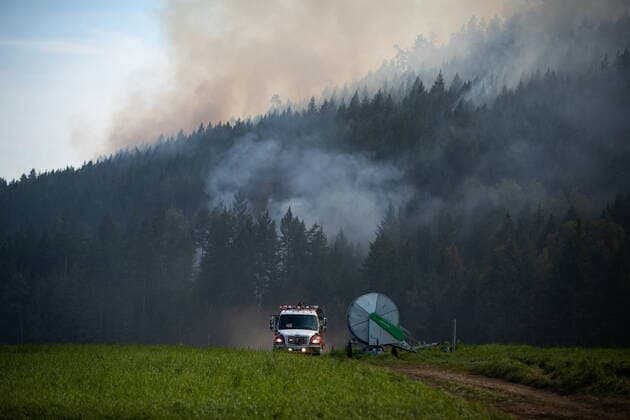 August 25, 2021, VERNON, BC, Canada: Firefighters drive across a farm while monitoring a controlled burn the B.C. Wildfire Service conducted to help contain the White Rock Lake wildfire on Okanagan Indian Band land, northwest of Vernon, B.C., on Wednesday, August 25, 2021. VERNON Canada  - ZUMAc35_ 20210825_zaf_c35_071 Copyright: xDarrylxDyckx