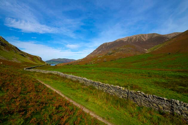 Footpath alongside a dry stone wall on Rannerdale Fell looking towards Crummock Water and fells in autumn. Copyright: xLoopxImages NigelxKirbyx NKI05521017