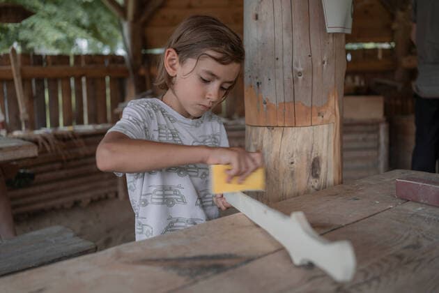 IMAGO Nature: Unsere Erde, Umweltverträgliche Herausforderungen, Recycling A focused boy sands the wooden sword CR_HABU2108223C-815417-01 ,model released, Symbolfoto