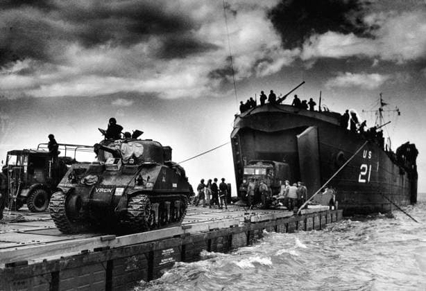 The U.S. Coast Guard manned USS LST-21 unloads British Army tanks and trucks onto a Rhino barge during the early hours of the invasion on Gold Beach. 6th June 1944. Normandy, France. ! ACHTUNG: AUFNAHMEDATUM GESCHÄTZT! *** Die von der US-Küstenwache bemannte USS LST 21 entlädt in den frühen Morgenstunden der Invasion am Gold Beach 6. Juni 1944 in der Normandie, Frankreich ACHTUNG AUFNAHMEDATUM GESCHÄTZT Panzer und Lastwagen der britischen Armee auf einen Rhino-Kahn