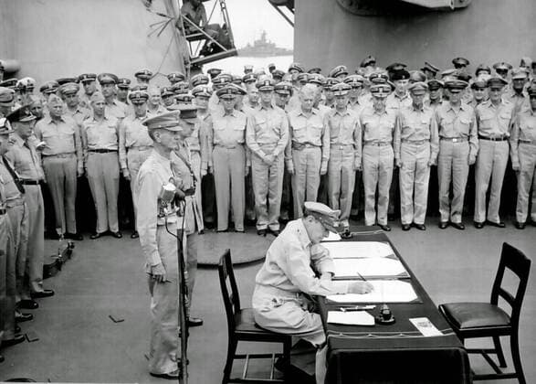 JAPANESE SURRENDER General Douglas MacArthur signs as Supreme Allied Commander during formal surrender ceremonies on the USS Missouri in Tokyo Bay. 2nd September 1945. Behind General MacArthur are Lieutenant General Jonathan Wainwright and Lieutenant General A. E. Percival. The unconditional surrender of the Japanese to the Allies officially ended World War 2. Tokyo Bay, Japan. 19450902 ! ACHTUNG: AUFNAHMEDATUM GESCHÄTZT!