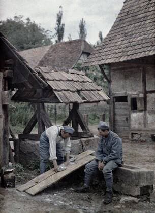 WORLD WAR I IN FRANCE Two French soldiers are taking care of their laundry using boards set up on the trough of a fountain near a farm house in the town of Gildwiller, Department Haut-Rhin, Region Alsace. 21st June 1917. Western Front. World War I. Autochrome Lumiere. Photo: Paul Castelnau (1880-1944). France. 19170621 ! ACHTUNG: AUFNAHMEDATUM GESCHÄTZT! *** WELTKRIEG IN FRANKREICH Zwei französische Soldaten waschen ihre Wäsche auf Brettern, die auf dem Trog eines Brunnens in der Nähe eines Bauernhauses in der Stadt Gildwiller, Departement Haut Rhin, Region Elsass 21. Juni 1917 Westfront Erster Weltkrieg Autochrom Lumiere Foto Paul Castelnau 1880 1944 Frankreich 19170621 ACHTUNG AUFNAHMEDATUM GESCHÄTZT
