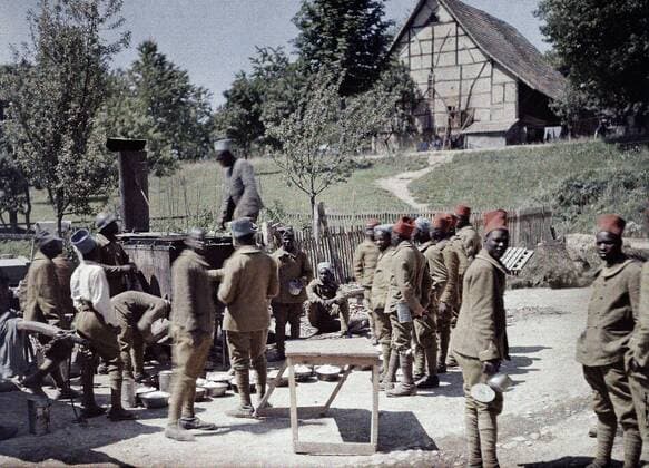 WORLD WAR I IN FRANCE A group of Senegalese soldiers serving in the French Army as infantrymen is having lunch in Saint-Ulrich, Department Haut-Rhin, Region Alsace. 16th June 1917. Western Front. World War I. Autochrome Lumiere. Photo: Paul Castelnau (1880-1944). France. 19170616 ! ACHTUNG: AUFNAHMEDATUM GESCHÄTZT! *** WELTKRIEG IN FRANKREICH Eine Gruppe senegalesischer Soldaten, die in der französischen Armee als Infanteristen dienen, isst zu Mittag in Saint Ulrich, Departement Haut Rhin, Region Elsass 16. Juni 1917 Westfront Erster Weltkrieg Autochrom Lumiere Foto Paul Castelnau 1880 1944 Frankreich 19170616 ACHTUNG AUFNAHMEDATUM GESCHÄTZT