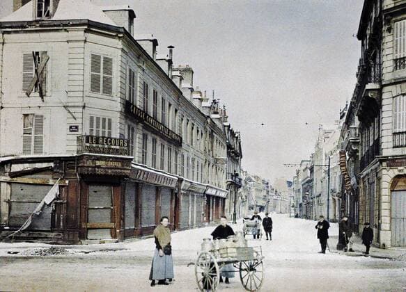 WORLD WAR I IN FRANCE A woman with a cart filled with milk cans in Rue de Vesle and a man with another cart in Rue de Talleyrand behind her. 3rd March 1917. There is still snow. Western Front. World War I. Autochrome Lumiere. Photo: Paul Castelnau (1880-1944). France. Reims, France. 19170303 ! ACHTUNG: AUFNAHMEDATUM GESCHÄTZT! *** WELTKRIEG IN FRANKREICH Eine Frau mit einem mit Milchkannen gefüllten Wagen in der Rue de Vesle und ein Mann mit einem anderen Wagen in der Rue de Talleyrand hinter ihr 3. März 1917 Es liegt noch Schnee Westfront Erster Weltkrieg Autochrom Lumiere Foto Paul Castelnau 1880 1944 Frankreich Reims, Frankreich 19170303 ACHTUNG AUFNAHMEDATUM GESCHÄTZT