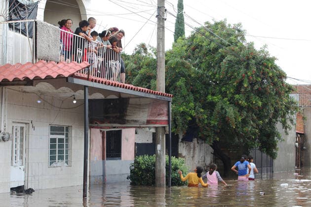 (210904) -- JALISCO, Sept. 4, 2021 -- Girls cross a street flooded due to heavy rains in the municipality of Tlaquepaque, State of Jalisco, Mexico, on Sept. 3, 2021. A strong storm during the early hours of Friday caused the El Chicharron and Las Pintas dams to overflow, flooding several areas of the municipality of Tlaquepaque. ) MEXICO-JALISCO-FLOOD ArturoxCampos 