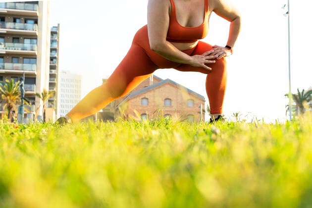 IMAGO Creative, Jahreszeit Sommer, Sommer in der Stadt Ground level of crop anonymous plump female athlete working out on lawn against urban buildings in sunlight DavidMunoz_MontseSport_43.jpg Copyright: xDavidxMunozx Model Released