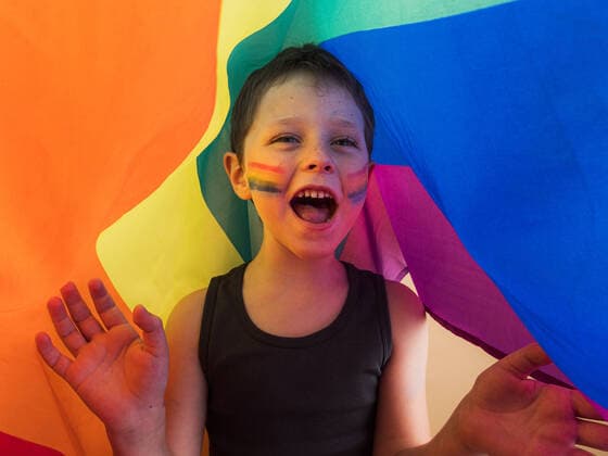 IMAGO Creative: Pride Month 2022, Engagement der Jugendlichen Positive child in undershirt with makeup on cheeks and open mouth yelling while looking away under LGBTQ flag HodeiUnzueta_EtxahumStudioConcepts_62.jpg Copyright: xHodeixUnzuetax Model Released