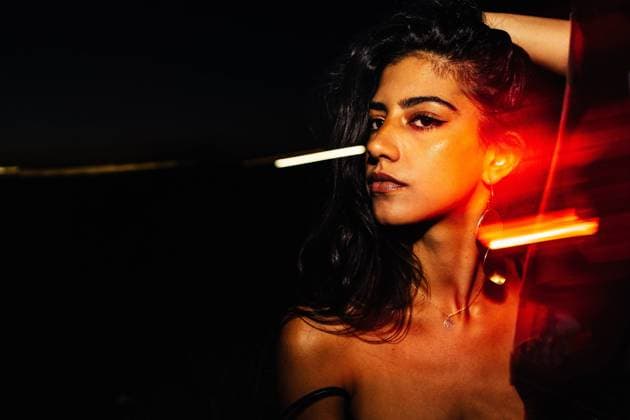 IMAGO Creative: Frauenmonat im M?rz IMAGO Creative: 2021 Favoriten Confident young Hispanic female with long wavy hair and bare shoulders keeping hand on head and looking at camera while standing near glass window with light reflections in darkness at night time JakeJakab_InesBoukheima_49.jpg Copyright: xJakexJakabx Model Released