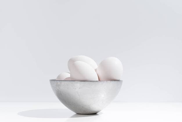 IMAGO Creative: Ostern Bowl with fresh chicken eggs placed on table on white background in studio RuthCarrodeaguas_ConceptualEggs_1.jpg Copyright: xRuthxCarrodeguasx Model Released