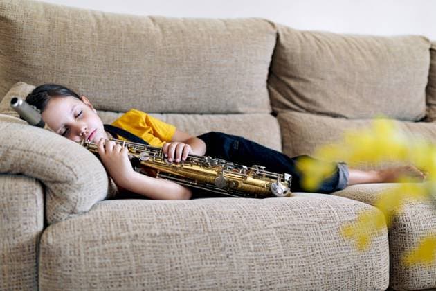 IMAGO Creative: Gesundheit, Stille Adorable child with saxophone napping on couch in house room, Model released SergioVictorVega_SaxoBeat_20.jpg Copyright: xSergioxVictorxVegax MR