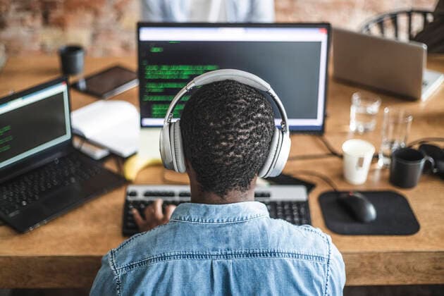 Rear view of male programmer working on computer at startup company Sweden, Stockholm, model released, property released Copyright: xMaskotx , MA87956