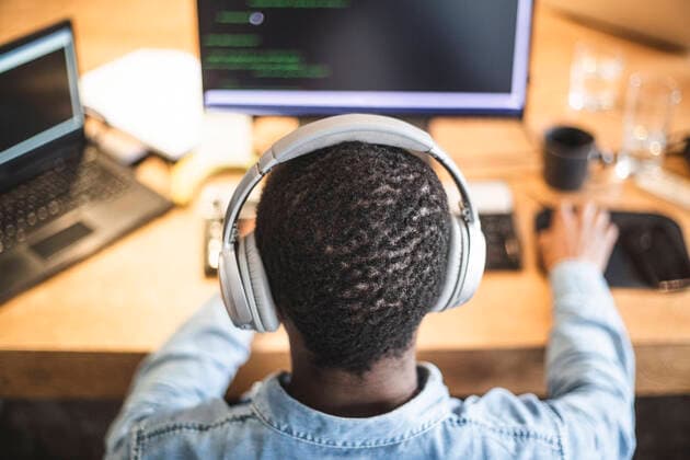 Rear view of male hacker working on computer at office Sweden, Stockholm, model released, property released Copyright: xMaskotx , MA87959
