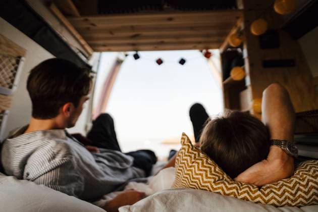 IMAGO Creative, Jahreszeit Herbst, Ferien IMAGO Creative: 2022 Aussichten IMAGO Creative: Klimawandel - Nachhaltiges Reisen Male friends lying down on bed in camping van Sweden, Gothenburg, model released, property released Copyright: xMaskotx , MA88054