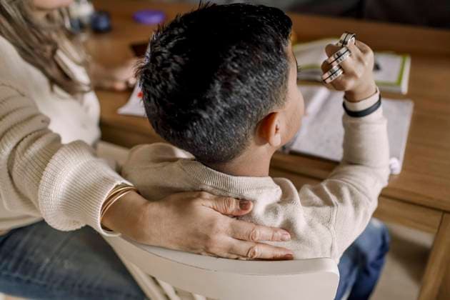 Autistic son with arm fist sitting by mother in living room Sweden, Stockholm, model released, property released Copyright: xMaskotx , MA88405