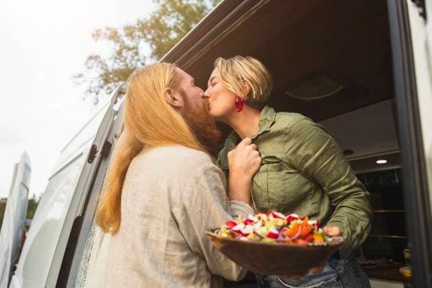 IMAGO Creative: Landleben - Essen IMAGO Creative: Landleben - Alfresco, Draußen Young couple kissing while standing in motor home during vacation Sweden, Gothenburg, model released, property released Copyright: xMaskotx , MA88433