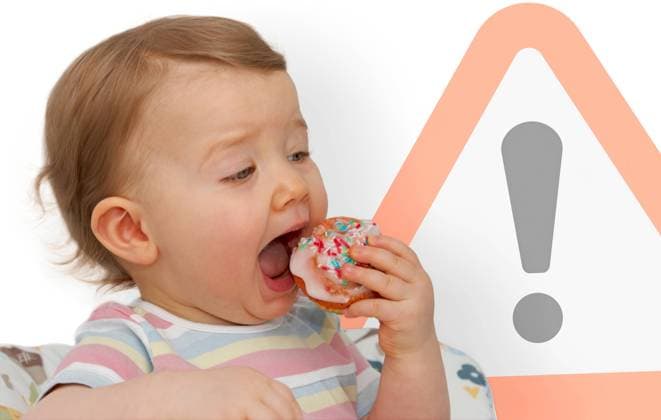 Kleinkind verspeist Muffin Symbolbild zum Thema Gefahr durch zu viel Zuckerkonsum bei Kindern. *** Toddler eats muffin Symbolic image on the subject of the danger of too much sugar consumption in children