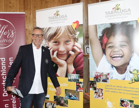 Tabaluga Golf Cup 2021 von Michael Roll Zum 27. Mal veranstaltete Michael Roll den Tabaluga Golf Cup zu Gunsten seiner Tabaluga Stiftung - Michael Roll vor einem Plakat der Tabaluga Stiftung, Tutzing Bayern Deutschland Golfclub Tutzing