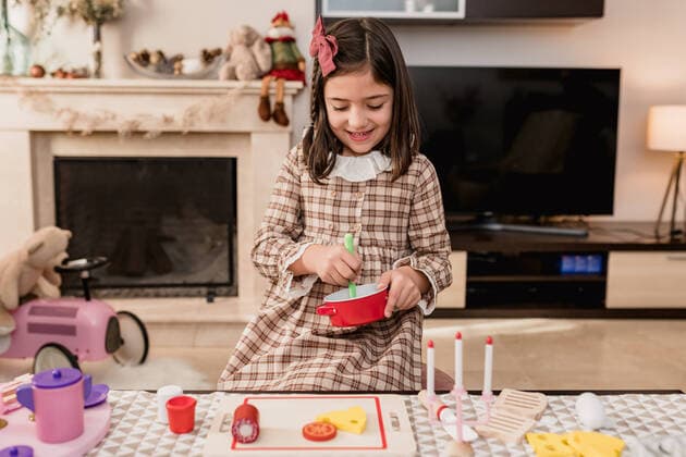 IMAGO Creative: Jahreszeit Winter, Fantasievoll drinnen spielen Attentive child in checkered dress playing with toys during cooking process at table in light room, Model released, Property released SiAndSi_Christmas_84.jpg Copyright: xSixAndxSix MR