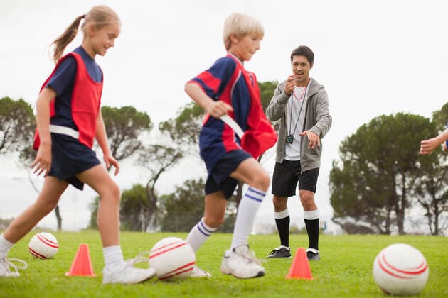 IMAGO Creative: Lokalhelden - Jugendsportbildung Coach training childrens soccer team, 09.07.2012, Copyright: xHybridxImagesx wearing,running,kicking,practising,recreation,playing,watching,focus on background,full length,authority,childhood,flexibility,aspiration,competition,effort,guidance,leadership,skill,togetherness,ambition,confidence,happiness,soccer ball,drill,mid adult,30 to 34 years,child,pre-adolescent child,caucasian ethnicity,girl,boy,mid adult man,small group of people,occupation,soccer player,outdoors,day,soccer pitch,uniform,vest,energy,pointing,shouting,standing,lifestyle,leisure,sport,soccer,coaching,teammate,coach,cone,small group,team,field,both male and female,elementary age,training,Shouting,Kicking,Physical Activity,Practising,Playing,Pointing,Running,Standing,Wat Ref:44ddt0659rf