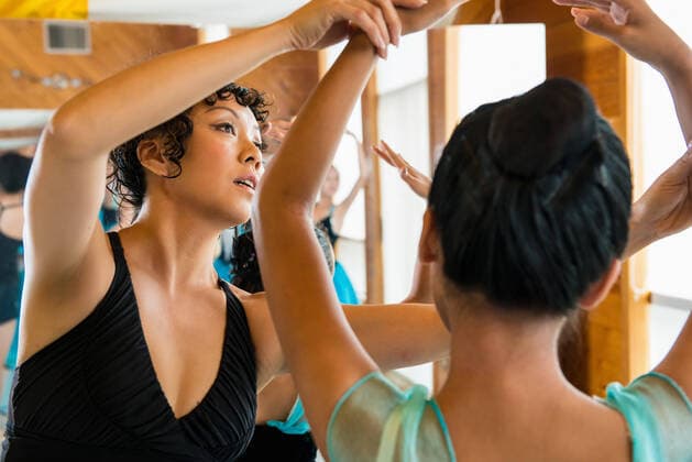 IMAGO Creative: Lokalhelden - Jugendsportbildung Mature ballet teacher with ballerinas, 06.08.2013, Copyright: xFlorinxPrunoiux, model released, wearing,ballet dancing,teaching,performing,practising,looking up,head and shoulders,advice,effort,grace,guidance,support,adult,mature adult,45 to 49 years,child,10 to 11 years,12 to 13 years,female,girl,woman,mature woman,two people,teacher,ballet dancer,indoors,sportswear,arms raised,balance,poised,only female,ballet school,dance studio,August 2013 Release,Gesturing,Arms Raised,Physical Activity,Dancing,Traditional Dancing,Ballet Dancing,Practising,Teaching,Looking Up,Mature Adult,45-49 Years,Child,Pre-Adolescent Child,10-11 Years,12-13 Years,Female,Women,Girls,Girl,Performer,Dancer,Ballet Dancers,Teacher,Advice,Balance,Effort,Grace,Guidance, Ref:IS09AA5WD