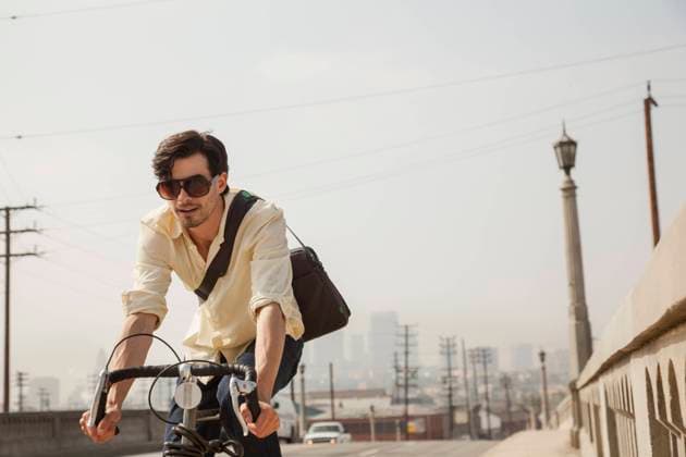 IMAGO Creative: Sport in der Stadt Man cycling on road, Los Angeles, California, USA, 05.11.2013, Copyright: xKevinxKozickix, model released, wearing,cycling,looking away,brown hair,diminishing perspective,focus on foreground,front view,waist up,wide angle,city living,carefree,fun,happiness,on the go,shoulder bag,25 to 29 years,caucasian ethnicity,male,man,young man,only one young man,commuter,one person,cyclist,city,united states of america,california,los angeles,outdoors,urban,day,road,street,casual clothing,sunglasses,shirt,jeans,smiling,lifestyle,sunlight,american culture,leisure,tourism,travel,commuting,vacation,city break,transport,racing bicycle,active lifestyle,building exterior,active,enjoyment,only male,November 2013 Release,buildings,Cycling,Looking Away,Caucas Ref:IS09AD9Q9