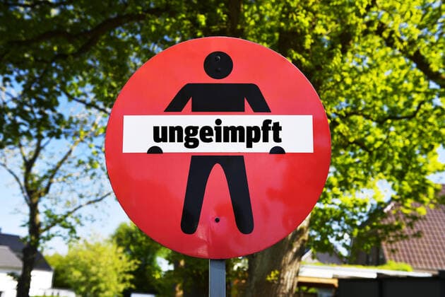 FOTOMONTAGE, Durchgangsverbotsschild mit Aufschrift ungeimpft