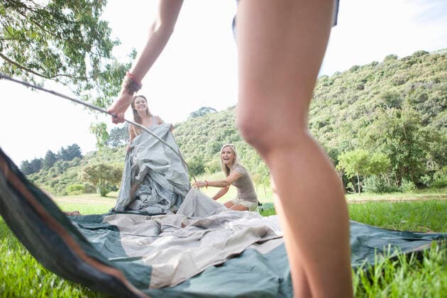 IMAGO Creative: Landleben - Alfresco, Draußen Three friends constructing tent whilst camping, 03.02.2014, Copyright: xZeroxCreativesx, model released, wearing,holding,camping,cropped,differential focus,low angle view,side view,three quarter length,wide angle,adventure,concentration,escape,bonding,carefree,cooperation,freedom,sharing,support,teamwork,togetherness,well being,friendship,happiness,getting away from it all,grass,metal rod,20 to 24 years,only young adults,18 to 19 years,anatomy,leg,caucasian ethnicity,mixed race ethnicity,multi-ethnic group,female,woman,young woman,three people,tent,outdoors,rural,field landscape,summer,smiling,standing,construction,lifestyle,sunlight,leisure,vacation,youth culture,enjoyment,only female,erecting,summer clothes,February 2014 Release,Standi Ref:IS09AG1N4