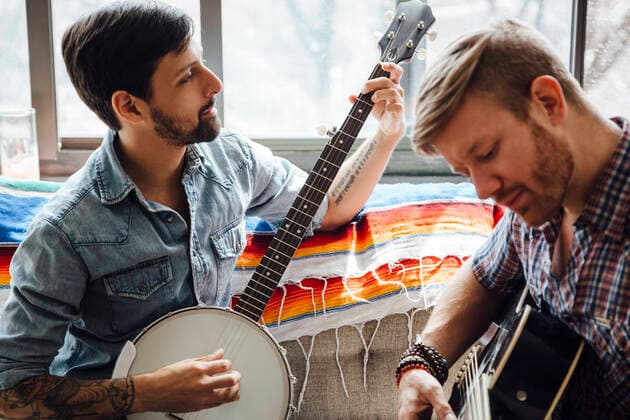 IMAGO Creative: Bildung, Musikerziehung Male couple at home, play guitar and banjo, 17.06.2015, Copyright: xAshleyxCorbin-Teichx, model released, wearing,learning,holding,playing,looking down,at home,concentration,focus concept,creativity,fun,inspiration,quality time,togetherness,friendship,happiness,love,relaxation,sofa,banjo,adult,mid adult,30 to 34 years,young adult,25 to 29 years,caucasian ethnicity,hispanic ethnicity,multi-ethnic group,male,man,mid adult man,only men,young man,homosexual couple,two people,gay man,house interior,indoors,living room,day,casual clothing,entertainment,sitting,smiling,music,leisure,display,mixed age group,playing guitar,comfort,only male,musical instrument string,June 2015 Release,Playing,Sitting,Thinking,Concentration,Learning,Holding,Looking Ref:IS09AS0NF