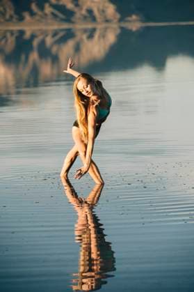 IMAGO Creative: Reflexionen - Sport Female ballet dancer poised bending forward in lake, Bonneville Salt Flats, Utah, USA, 02.02.2016, Copyright: xPetexSaloutosx, model released, wearing,ballet dancing,performing,blond hair,full length,concepts,feminine,flexibility,athleticism,beauty,creativity,freedom,grace,serene people,25 to 29 years,caucasian ethnicity,female,woman,young woman,only one young woman,one person,dancer,ballet dancer,united states of america,utah,outdoors,rural,lake,summer,day,bikini,energy,long hair,water,bending forward,poised,landscape,only female,reflection lake,effortless,ethereal,natural landmark,ballet position,bonneville salt flats,February 2016 Release,Bending Over,Physical Activity,Dancing,Traditional Dancing,Ballet Dancing,Caucasian Ethnicity,You Ref:IS09AW0IF