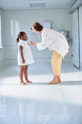 Female doctor using stethoscope on girl in hospital children s ward, 05.07.2016, Copyright: xFrankxandxHelenax, model released, , property released, wearing,listening,using,working,copy space,full length,side view,childhood,concentration,curiosity,responsibility,bonding,care,innocence,skill,trust,50 to 54 years,child,caucasian ethnicity,multi-ethnic group,female,girl,woman,mature woman,two people,medical occupation,doctor,patients,indoors,hospital,examination gown,lab coat,illness,medical,pediatrics,monitoring,6 to 7 years,african ethnicity,attentive,health service,patient,only female,healthcare,acoustic stethoscope,July 2016 Release,childrens ward,Thinking,Concentration,Hearing,Listening,Working,African Descent,Caucasian Ethnicity,Multi- Ref:IS09AZ9F8