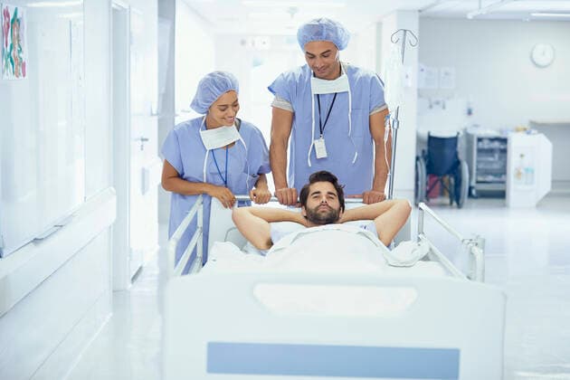 Young male patient in hospital bed being pushed by nurses, 15.09.2016, Copyright: xFrankxandxHelenax, model released, , property released, wearing,lying on back,pushing,working,blue,front view,waist up,responsibility,care,cooperation,skill,teamwork,relaxation,on the go,35 to 39 years,20 to 24 years,caucasian ethnicity,mixed race ethnicity,multi-ethnic group,woman,young woman,man,mid adult man,young man,three people,medical occupation,indoors,south africa,hospital,hospital ward,surgical cap,medical clothing,surgical scrubs,protective clothing,hands behind head,medical treatment,medicine,hospital bed,patient,both male and female,health-and-safety,paarl,healthcare,en route,September 2016 Release,Pushing,Hands Behind Head,Reclining,Lying On B Ref:IS09B23VM