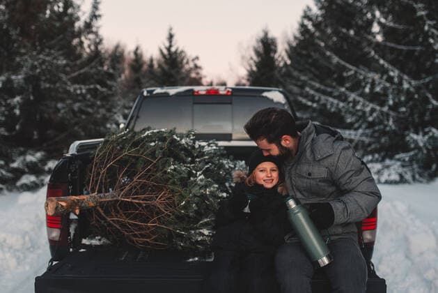 IMAGO Creative: Countdown bis Weihnachten, Nach Hause reisen Father and daughter on back of pick up truck with their Christmas tree, 16.01.2017, Copyright: xKymberliexDozoisxPhotographyx, model released, wearing,learning,holding,looking at camera,black color,gray color,focus on foreground,portrait,three quarter length,parenthood,achievement,bonding,teamwork,togetherness,affection,love,fir tree,coffee flask,christmas tree,25 to 29 years,back,female,girl,male,man,young man,two people,canada,ontario,outdoors,forest,winter,day,glove,christmas,sitting,daughter,father,single parent,hot drink,taking a break,snow,automobile boot,pick-up truck,5 to 6 years,family with one child,puffer jacket,warm clothing,winter coat,pecking,gray sky,peterborough ontario,February 2017 Release,Pecking,Sitting,Resting,Taking Ref:IS09B40H9