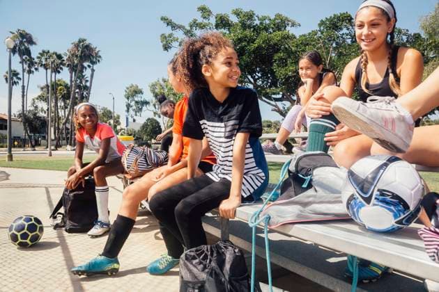 IMAGO Creative: Lokalhelden - Jugendsportbildung Schoolgirl soccer players chatting on school sports field bench, 12.12.2017, Copyright: xAshleyxCorbin-Teichx, model released, wearing,talking,learning,practising,recreation,side view,three quarter length,adolescence,anticipation,childhood,bonding,cooperation,fitness,innocence,sharing,teamwork,togetherness,confidence,friendship,happiness,bench,child,10 to 13 years,teenager,13 to 15 years,caucasian ethnicity,hispanic ethnicity,multi-ethnic group,female,girl,teenage girl,pre-adolescent girl,eight people,medium group of people,schoolgirl,soccer player,school,united states of america,california,outdoors,summer,day,playing field,sportswear,education,smiling,sport,soccer,active lifestyle,long beach,physical education,only female,8 to 9 years,s Ref:IS09B9GV1