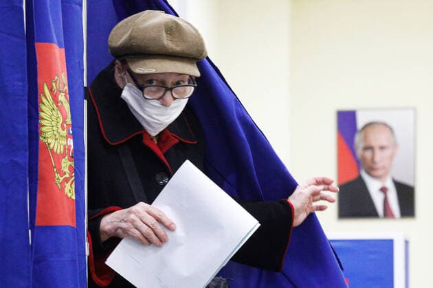 Bilder des Jahres 2021, News 09 September News Themen der Woche KW37 Russian Parliamentary Election In Moscow A woman at a polling station walks past a portrait of Russian President Vladimir Putin during a vote in the State Duma of the Russian Federation in St. Petersburg. Saint Petersburg, Russia, September 19, 2021 Moscow Russia egorshin-notitle210917_npemM  Copyright: xValyaxEgorshinx
