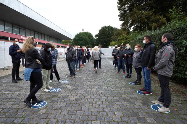 Konzertbesucher warten auf nummerierten Plätzen auf der Ergebnis der Probenuntersuchung durch die Corona-Spürhunde bei einem Testkonzert mit Fury in the Slaughterhouse im Rahmen der Konzertreihe Back to Culture in Verbindung mit einer Teststudie mit Corona-Spürhunden auf der Gilde Parkbühne. Hannover, 19.09.2021