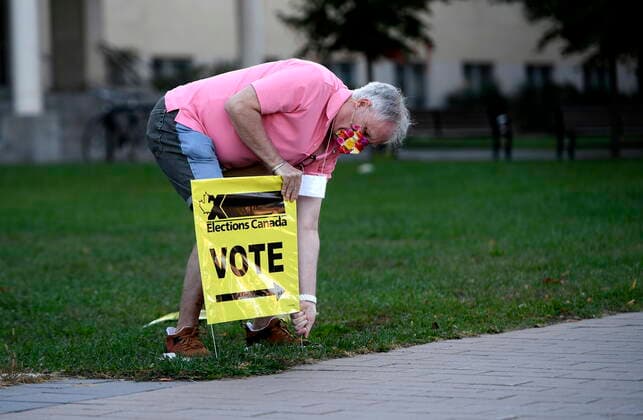 September 20, 2021, Ottawa, on, Canada: An Elections Canada officer stakes out signs in Ottawa directing voters to a polling location for the Canadian general election on Monday, Sept. 20, 2021. Ottawa Canada  - ZUMAc35_ 20210920_zaf_c35_009 Copyright: xJustinxTangx