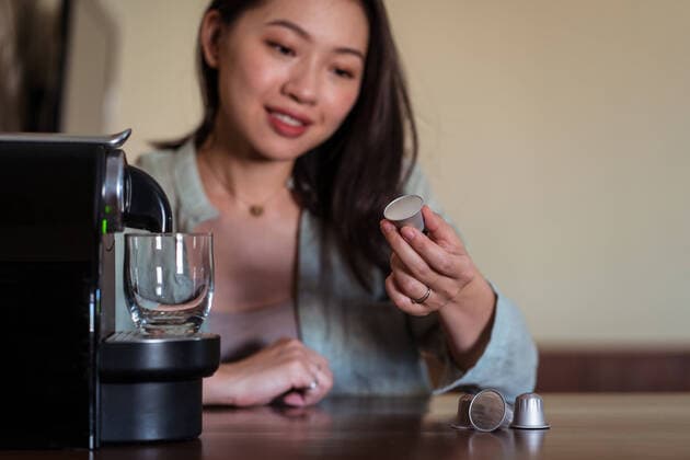 IMAGO Creative: Haushaltsger?te - Kaffeemaschine Crop smiling young ethnic female putting coffee pod in maker on table in house kitchen, Model released JuanAlbertoRuiz_CoffeeAtHome_3.jpg Copyright: xJuanxAlbertoxRuizx MR