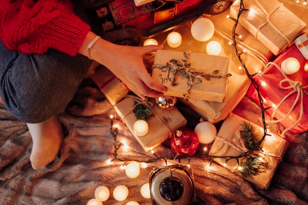 Young woman holding wrapped gift during Christmas at home model released Symbolfoto property released EGHF00177