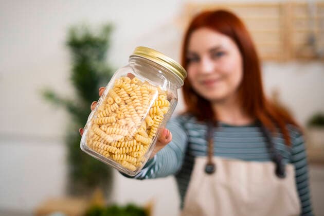 Woman holding pasta jar in kitchen model released Symbolfoto property released GIOF13223
