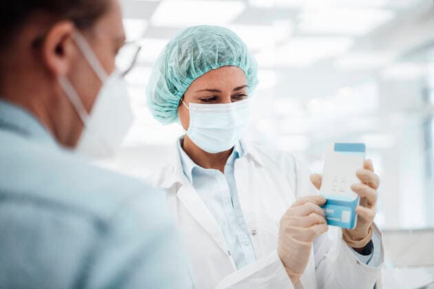 Female pharmacist in protective face mask explaining medicine to male customer in pharmacy store model released Symbolfoto property released JOSEF05433
