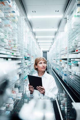 Female pharmacist holding digital tablet while searching medicine at medical store model released Symbolfoto property released JOSEF05464