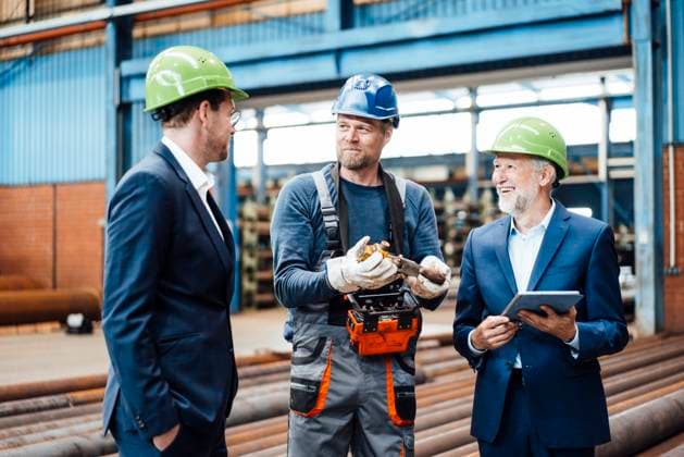 IMAGO Creative: Corporate: Klimaschutz, Digitalisierung und Urbanisierung Male managers discussing over equipment with coworker in industry model released Symbolfoto property released JOSEF05701